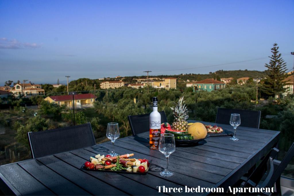 蒂锡利维Dionisos Luxury Suites的一张木桌,上面放着一瓶葡萄酒和食物