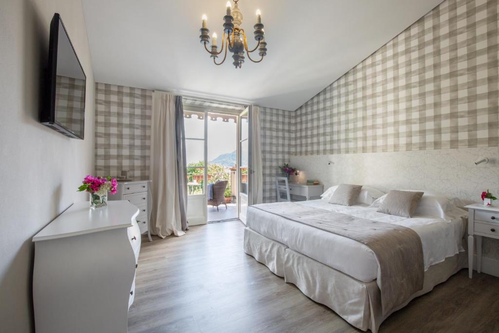 坎诺比奥Park Hotel Villa Belvedere的一间卧室配有一张大床和一个吊灯。