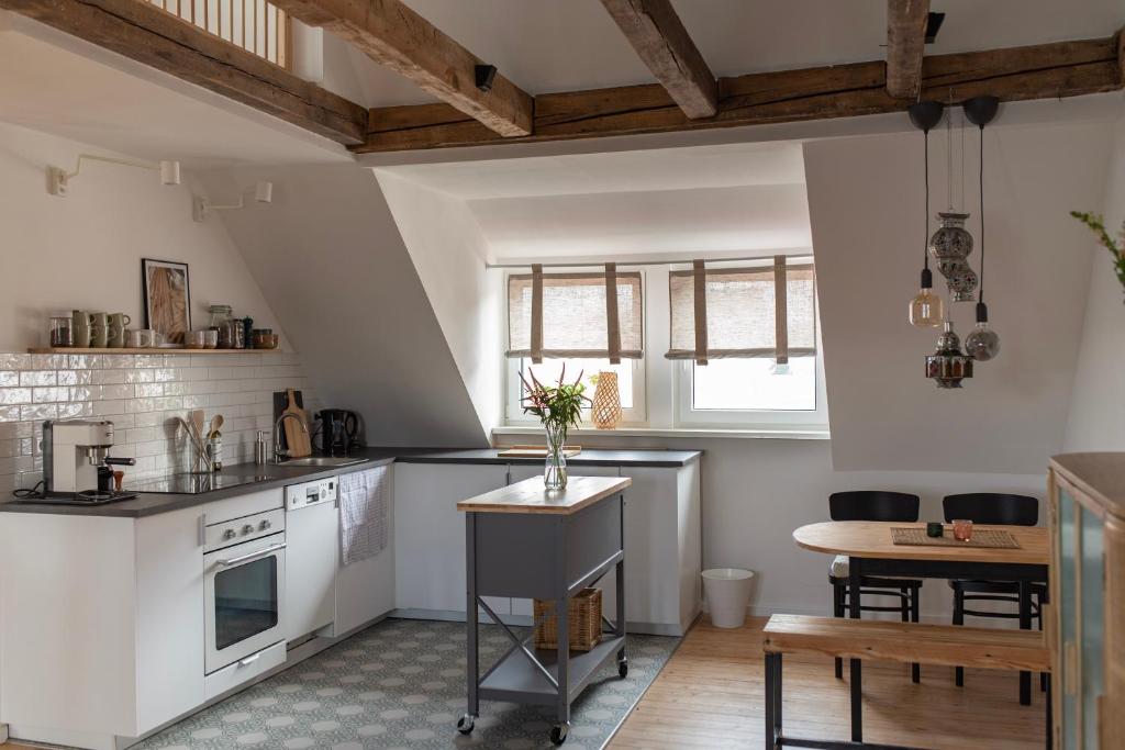 阿沙芬堡Altbau Appartement - klein aber oho的厨房配有白色的柜台、桌子和桌子