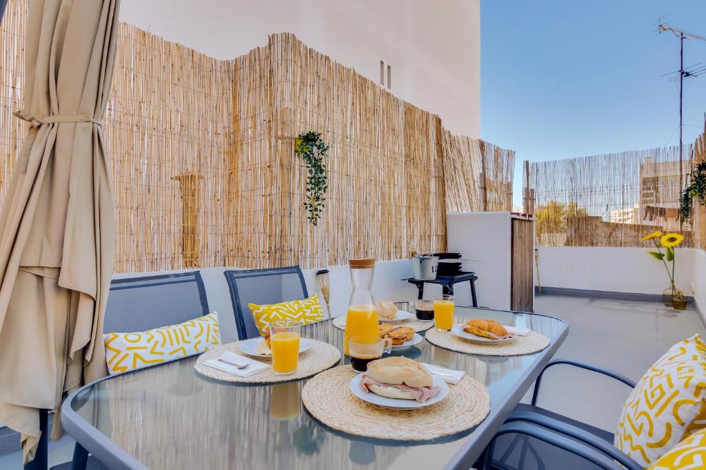 法鲁Faro: Casa Trevo com terraço BBQ的玻璃桌,带两盘食物和橙汁