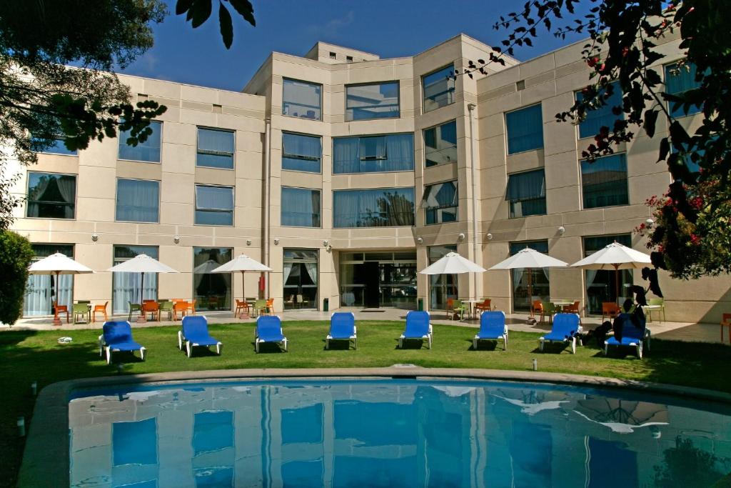 拉塞雷纳科斯塔皇家酒店的一座建筑前的带椅子和游泳池的酒店