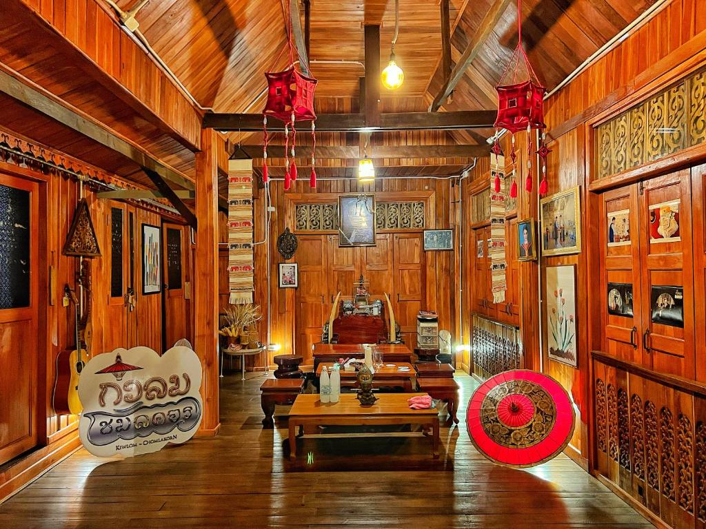 南邦กิ่วลม - ชมลคอร Kiwlom - Chomlakorn, Lampang, TH的木墙客房和带桌子的客房