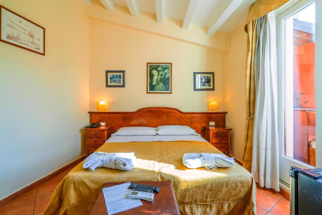 锡拉库扎地中海酒店的一间卧室配有一张床,上面有两条毛巾