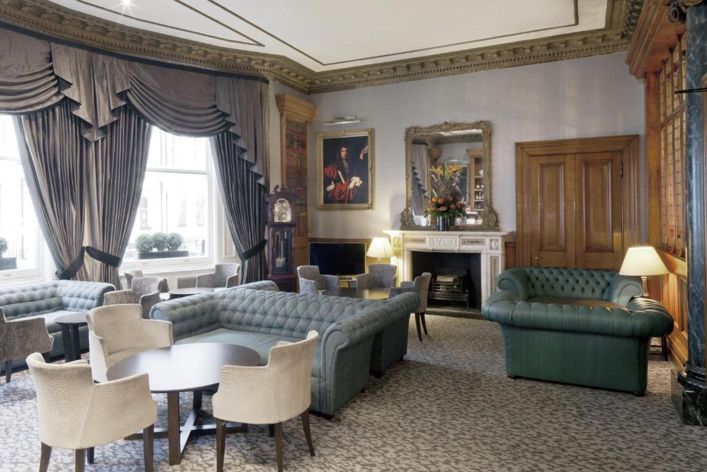 伦敦Gem Strathmore Hotel的带沙发和桌子的客厅以及壁炉。