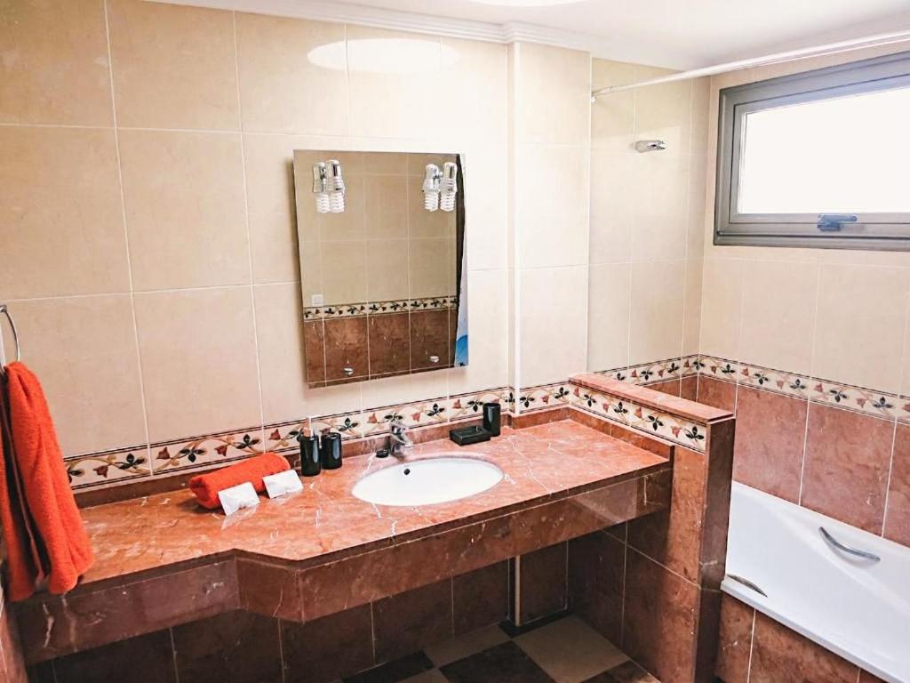 厄尔梅达诺Bungalow with 2 bedrooms, Playa la Tejita的一间带水槽、浴缸和镜子的浴室