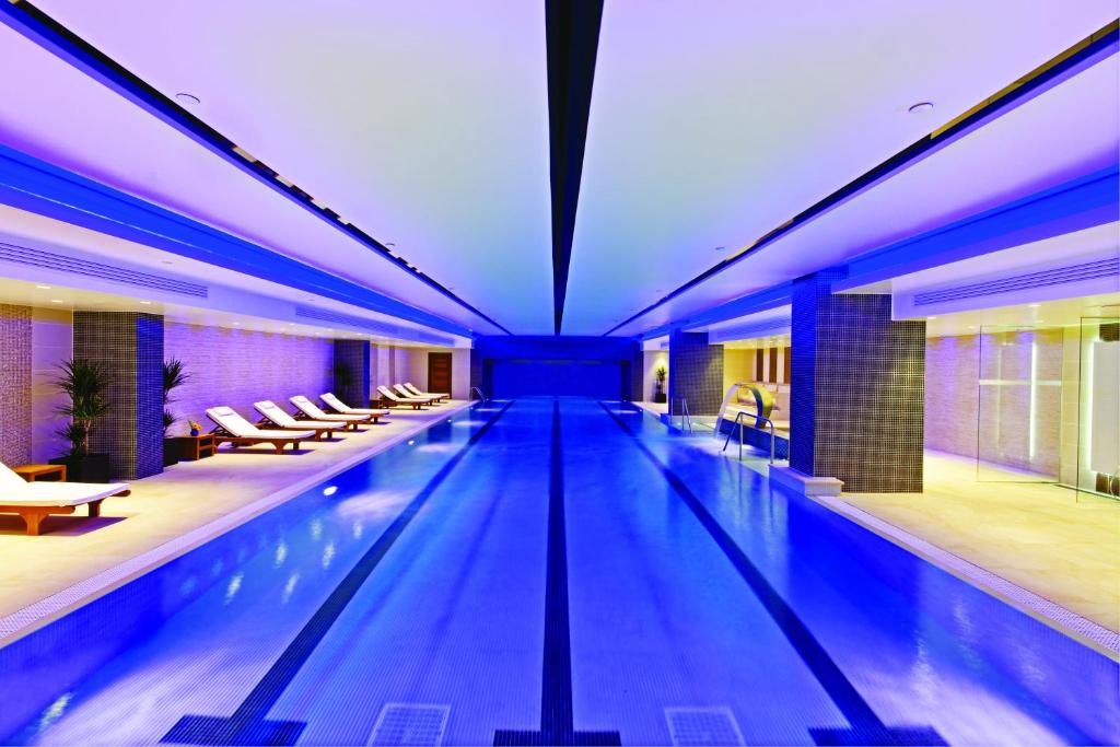 伦敦Leonardo Royal London Tower Bridge的蓝色灯光的酒店的大型游泳池