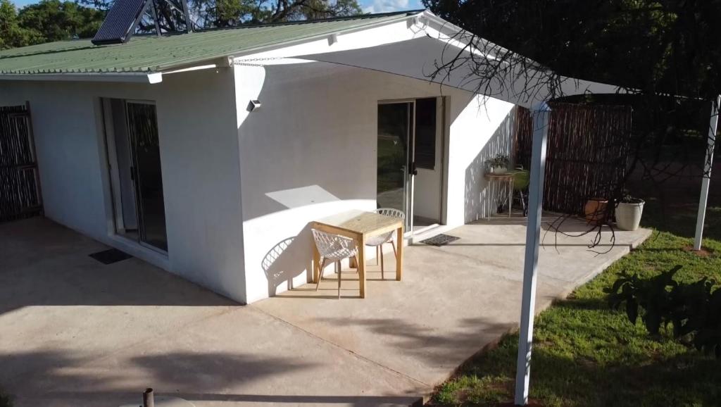 DalmadaPan's Breeze Overnight Accommodation的白色的房子,配有两把椅子和一张桌子