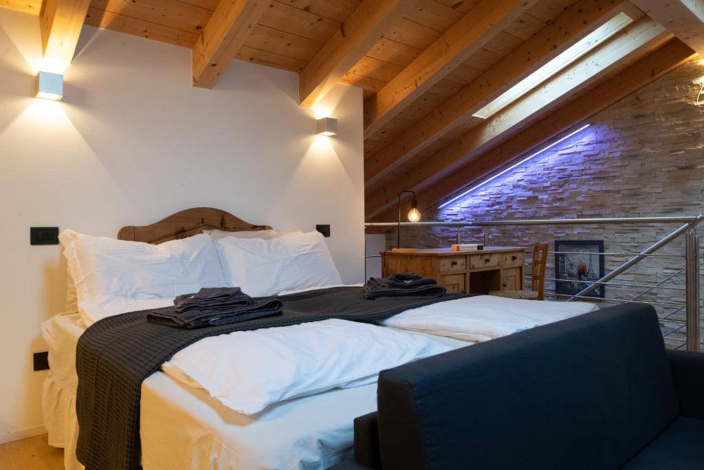卡尔多纳佐Relax in Pineta的一间卧室配有一张带白色床单的床和一扇窗户。