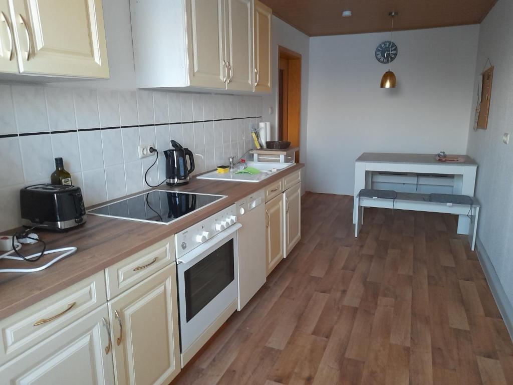 茨维考2 Raum Wohnung im DG的厨房配有白色橱柜、水槽和炉灶。