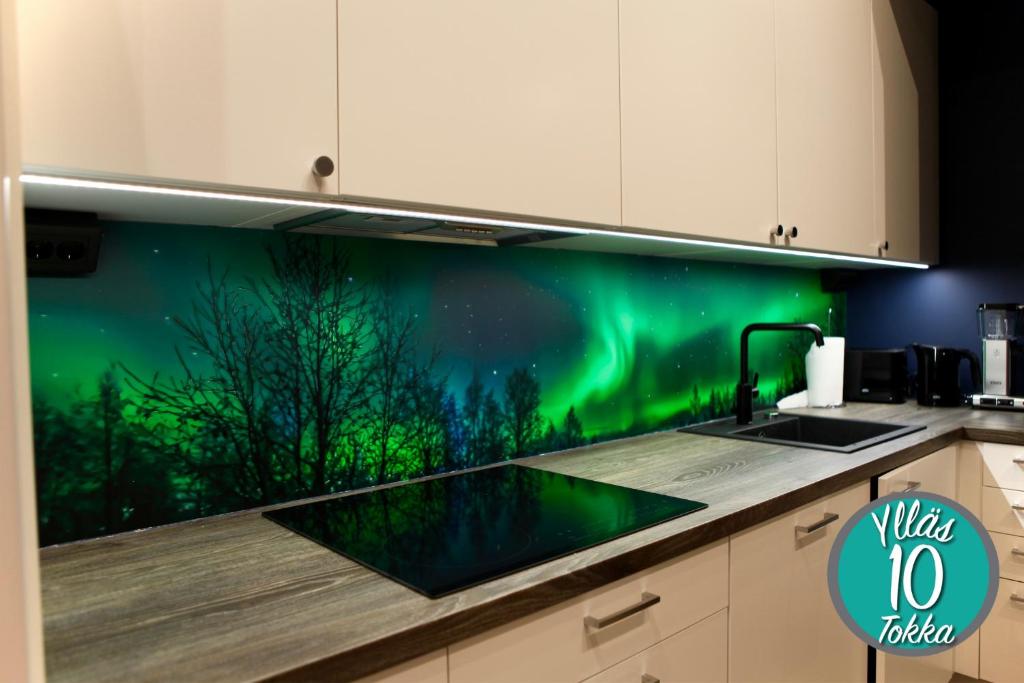 易拉斯加威Yllästokka 10的厨房设有一面带北极光的绿色墙壁