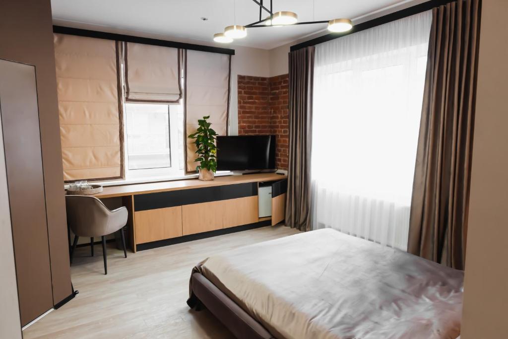 伊万诺-弗兰科夫斯克Miracle Place的一间卧室配有一张床、一张书桌和一台电视