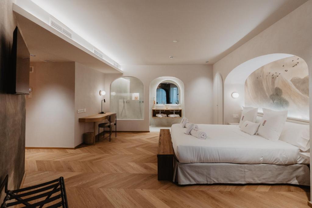 特拉萨Hotel Petit Luxe的卧室配有一张白色大床和一张书桌