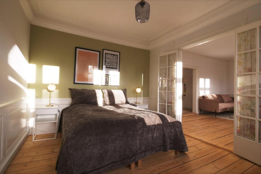 哥本哈根New Harbor - Carolinas Apartment的一间卧室配有一张床、两盏灯和一张沙发。