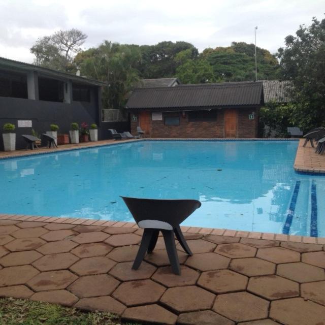 圣卢西亚For your family Manzini 1的游泳池前的一张黑椅