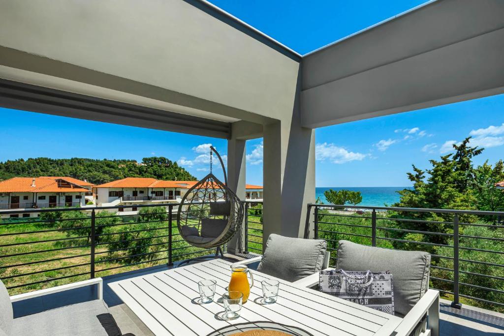 波塞蒂NewStory Luxury Suites Possidi的一个带桌椅的海景庭院