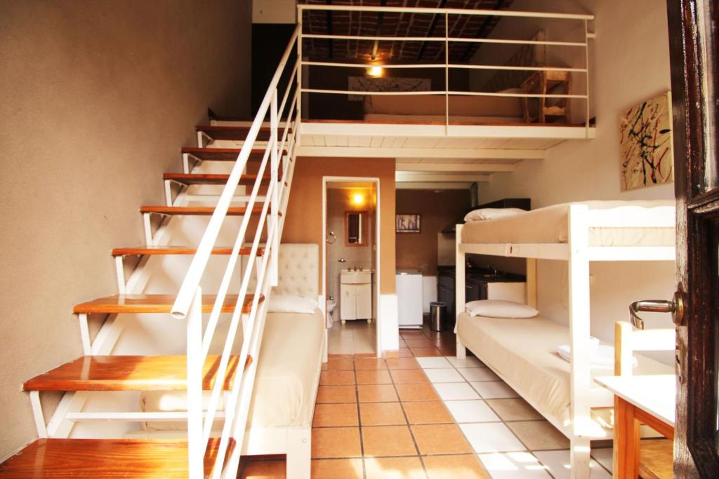 蒂格雷台达港酒店的宿舍间设有双层床和楼梯。