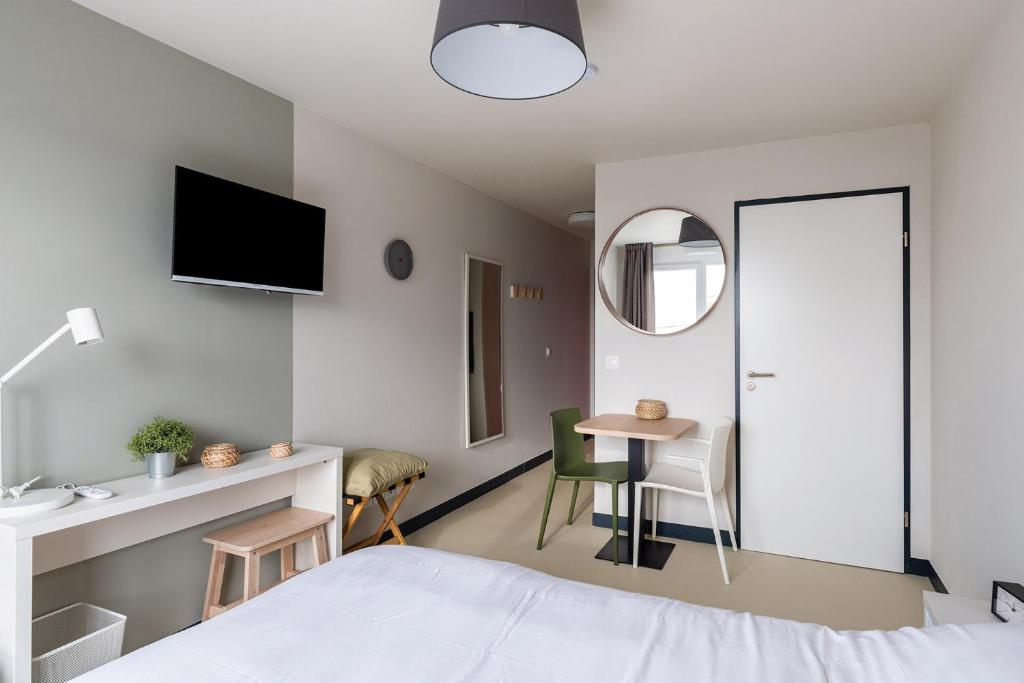 勒阿弗尔Student Factory Le Havre Les Docks的一间卧室配有一张床、一张桌子和一面镜子