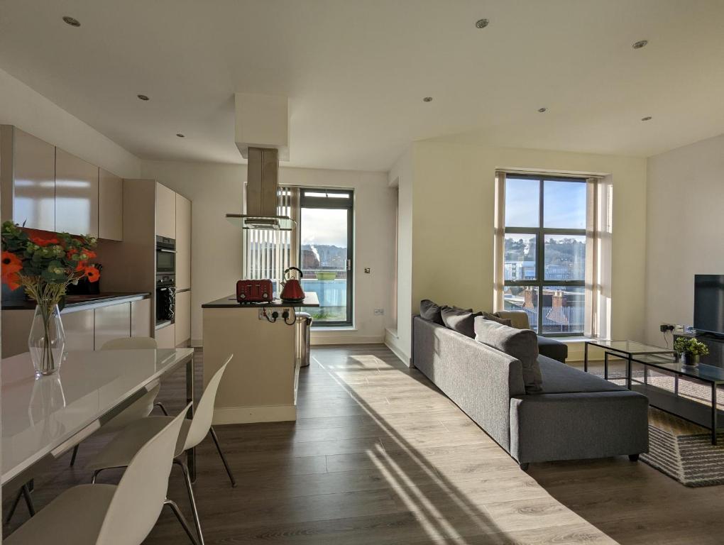 海维康Bankside by Wycombe Apartments的厨房以及带沙发和椅子的客厅。