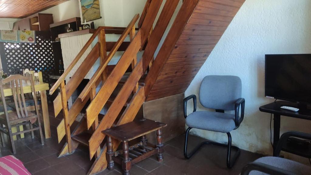 拉帕洛马Casa en Barrio Country - La Paloma的客房设有楼梯、椅子和电视。