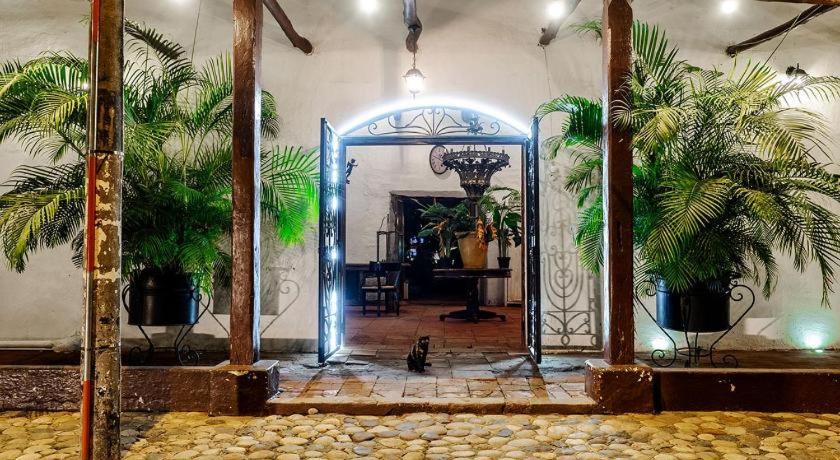比利亚维哈Hotel Infinito La Casona的通向两棵棕榈树的房间的开放式门