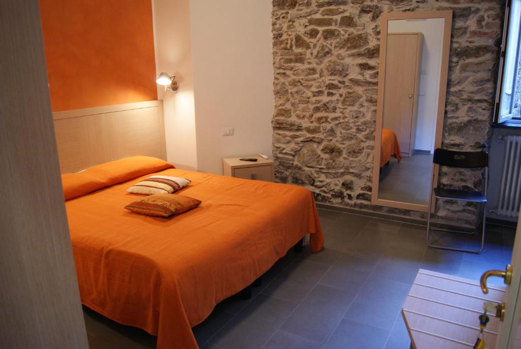 里奥马哲雷索尔萨酒店的一间卧室配有带橙色床单和镜子的床