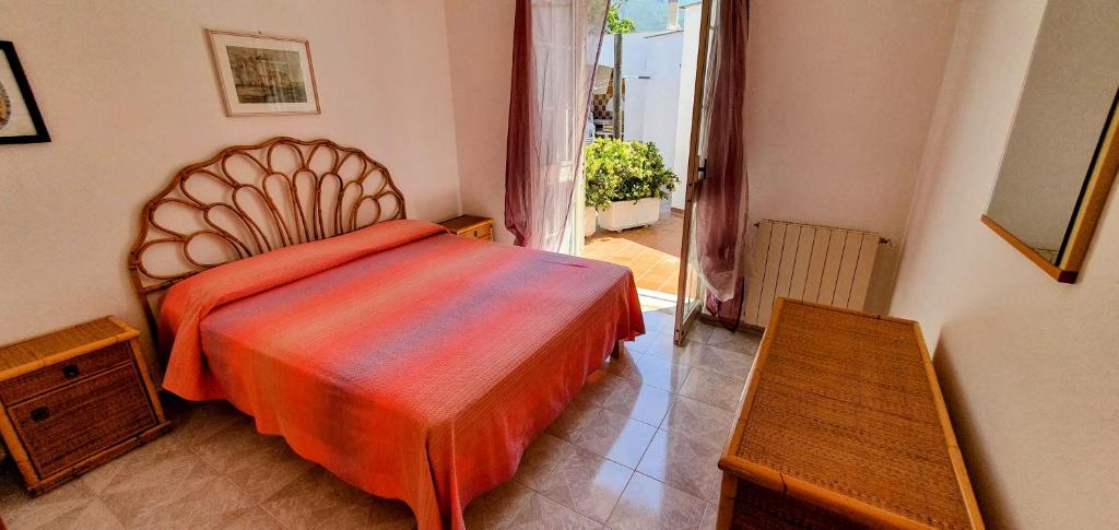 伊斯基亚Appartamenti Luongo的一间卧室配有一张带橙色棉被的床
