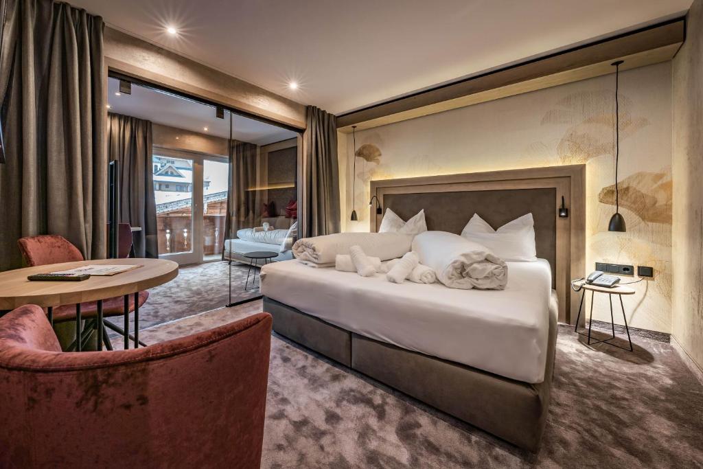 迈尔霍芬布鲁克酒店的一间卧室配有一张大床和一张桌子及椅子