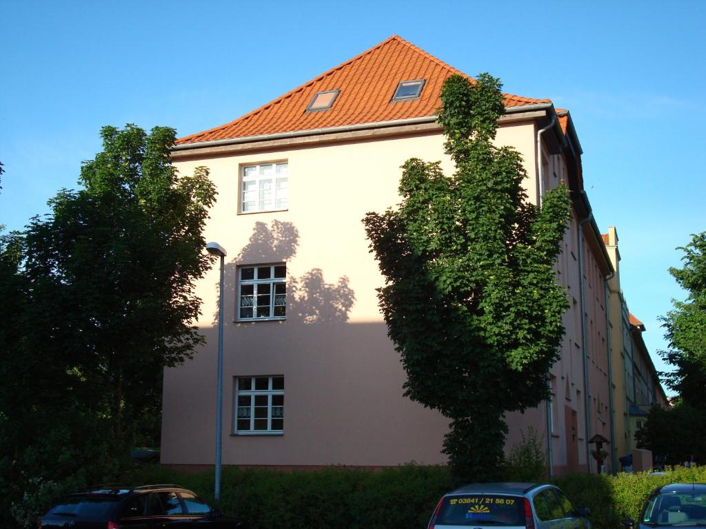 维斯马Ferienwohnung Henny的前面有棵树的白色建筑