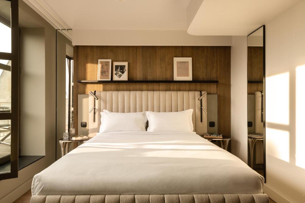 巴黎Hôtel Dame des Arts的卧室设有一张白色大床和一扇窗户。
