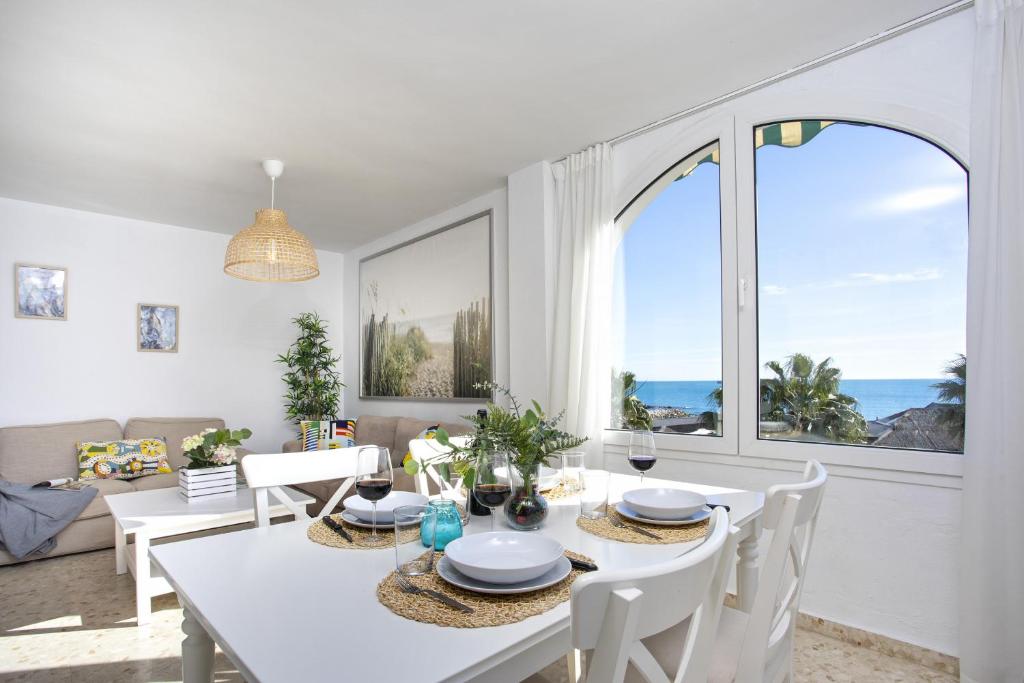 马拉加-MalagaSunApts-WEST Malaga Amazing SeaView的一间带桌椅和大窗户的用餐室