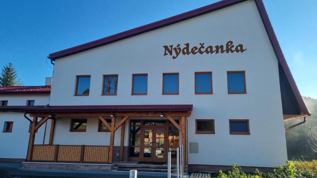 NýdekApartmány Nýdečanka的一座白色的大建筑,上面有标志