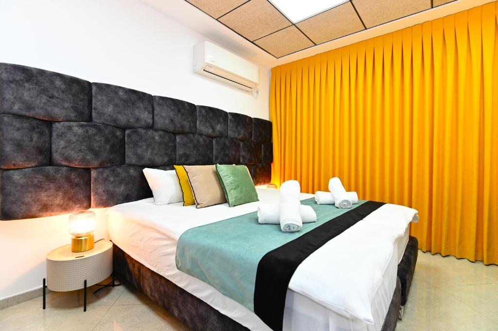 提比里亚Yalarent Malina motel in Tiberias的一间卧室配有一张大床和两条毛巾