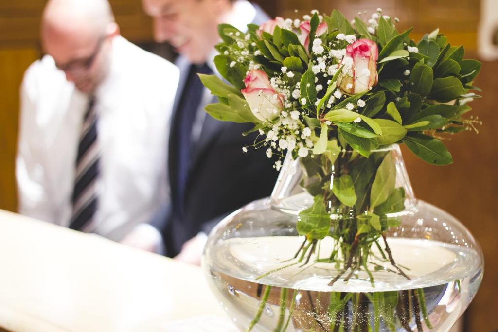 雅典萨皮恩酒店的花瓶,满是花,摆在桌子上,人