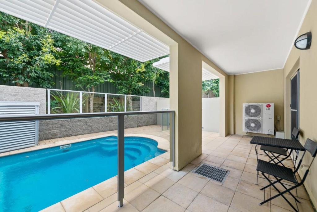 萨拉曼德湾Pacific Blue 520 private pool air conditioning and Wi Fi的带阳台的房子内的游泳池