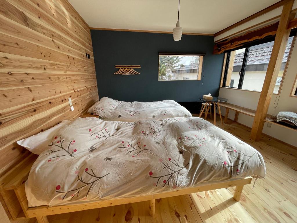野沢Yubaba House Downtown Apartments的一间卧室配有一张木墙床