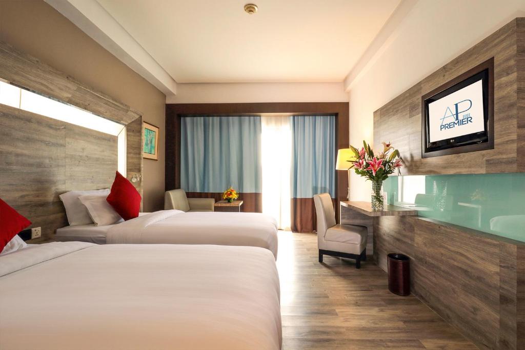 名古屋AP Premier Batam的一间酒店客房,设有两张床和电视