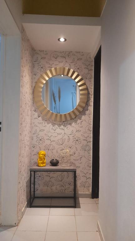 MacoC & J Casa de alquiler的墙上的镜子,桌子在房间里
