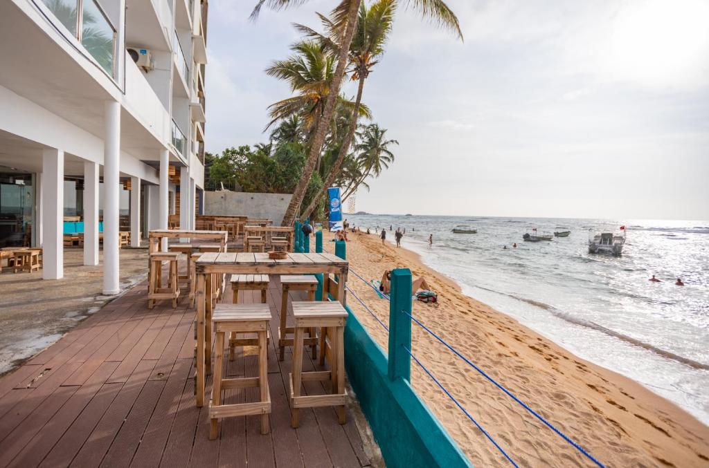希克杜沃希克杜沃海滩酒店的海滩上设有桌椅,大海上设有沙滩
