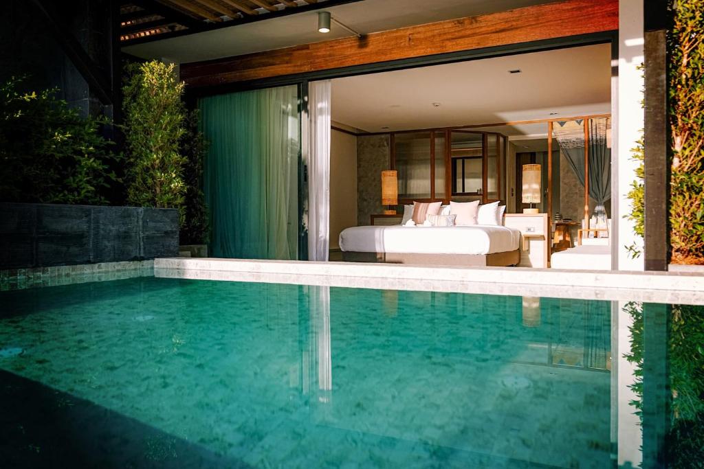 Ban Thong Yangสิชลเตโซโร的卧室前的游泳池,带一张床