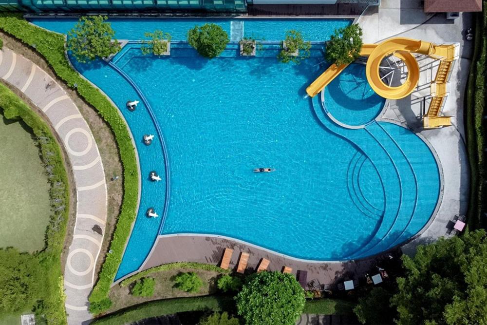 邦盛Bangsaen Heritage Hotel - SHA Plus Certified的享有带水滑梯的游泳池的上方景色