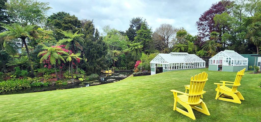 斯特拉特福德Brecon Pond Bed & Breakfast的两把黄色椅子和一个院子中的温室