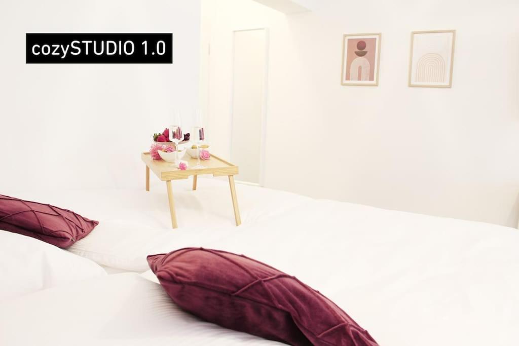 杜伊斯堡SECRET HIDEAWAYS cozySTUDIO 1 superior Apartment mit WiFi l 450m bis Uni l Zoo的一间设有两张枕头的床铺和一张桌子的房间