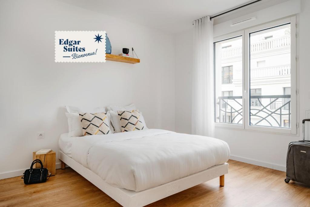 勒瓦卢瓦-佩雷Edgar Suites Levallois – Jules Verne的白色的卧室设有床和窗户