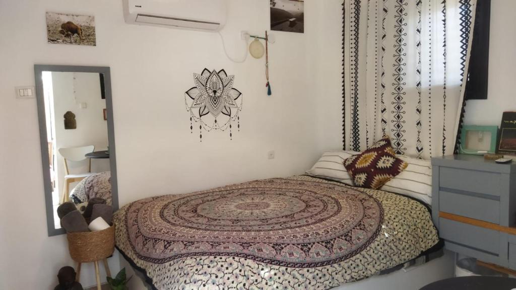 阿拉德מקום קטן בשלווה a little peaceful place的一间卧室配有一张铺着地毯的床