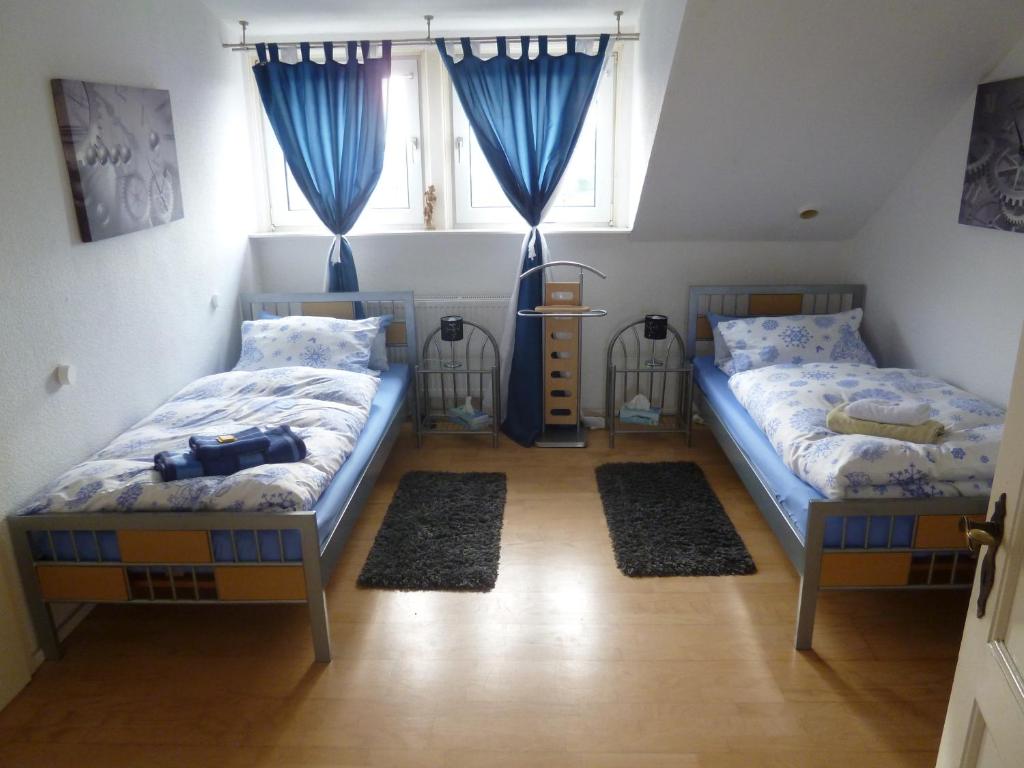 杜塞尔多夫机场公寓式酒店的配有蓝色窗帘的客房内的两张床