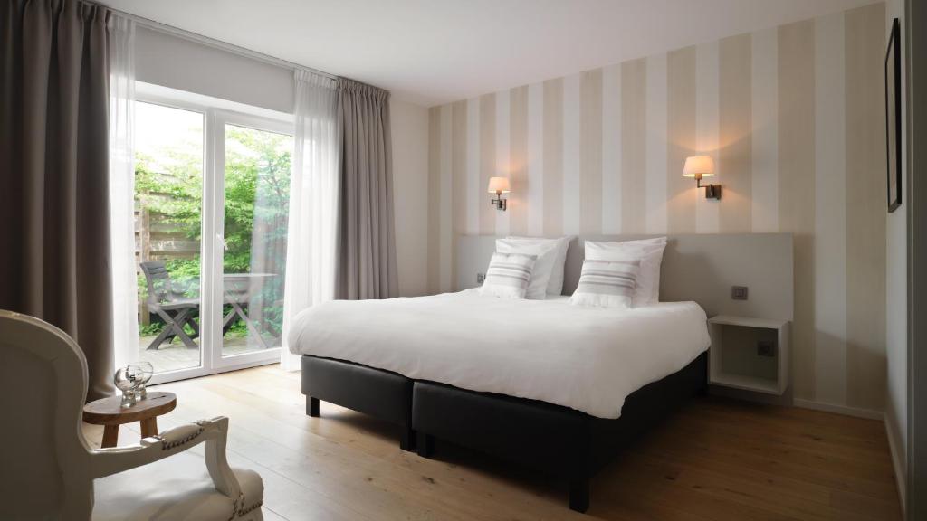 斯帕Le 24 Hotel的酒店客房设有床和窗户。