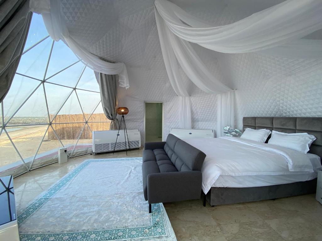 鲁瓦斯Turquoise Resorts的一间卧室配有一张床、一张沙发和一个大窗户