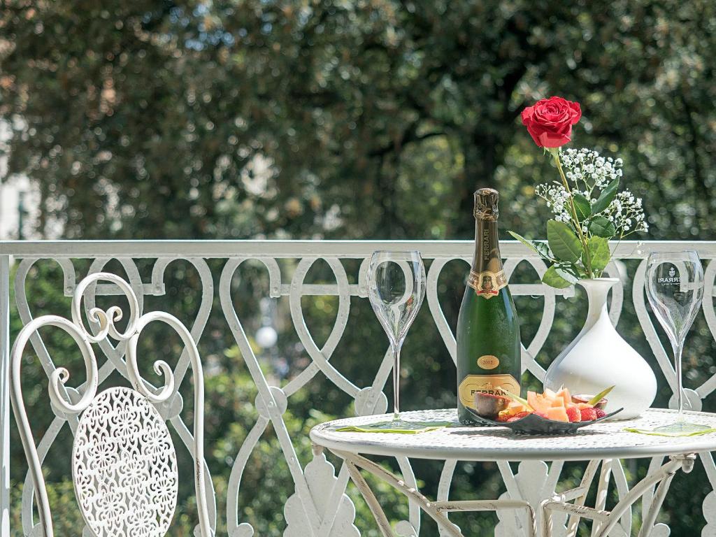 斯培西亚维亚尼住宅旅馆的一张桌子,上面放着一瓶香槟和玫瑰