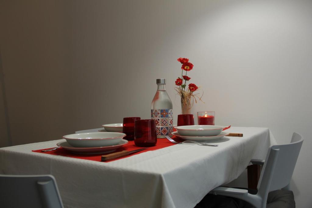 斯培西亚The Blue Nest - Red Apartment near 5 Terre的一张桌子,上面有白色的桌布和盘子,还有一瓶