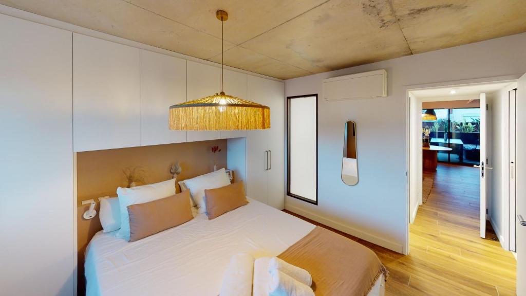 卡诺海滩Villa Ananda - Chandra - Un havre de paix entre mer et étangs的卧室配有一张白色大床和吊灯。